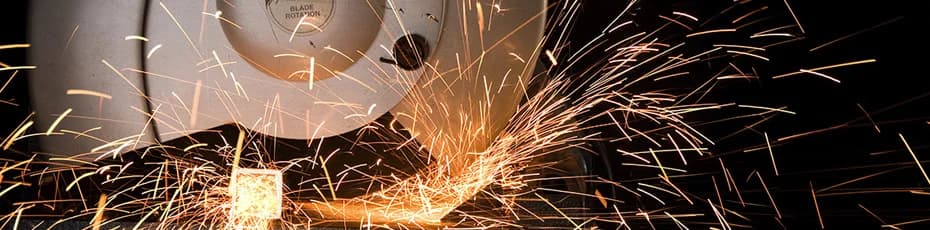 Bandsaw cutting steel with sparks at Territory Steel processing facility